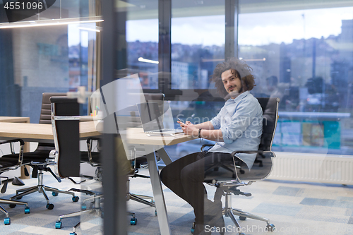 Image of Young casual businessman using smartphone