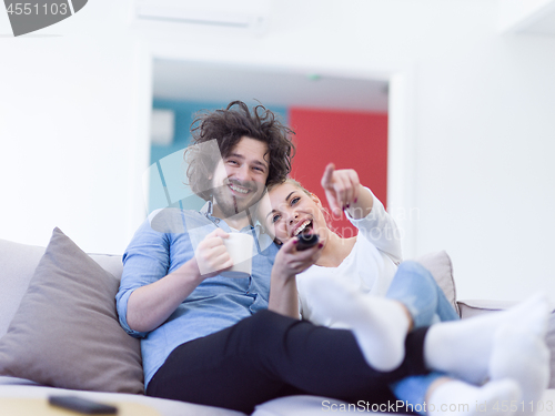 Image of Young couple on the sofa watching television