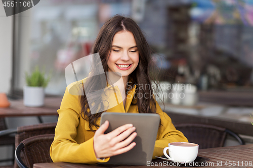 Image of teenage girl with tablet pc and drink at cafe