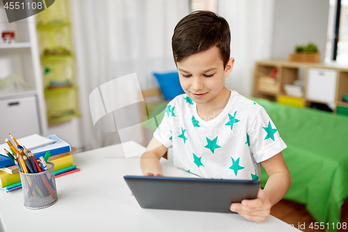 Image of student boy with tablet pc and notebook at home