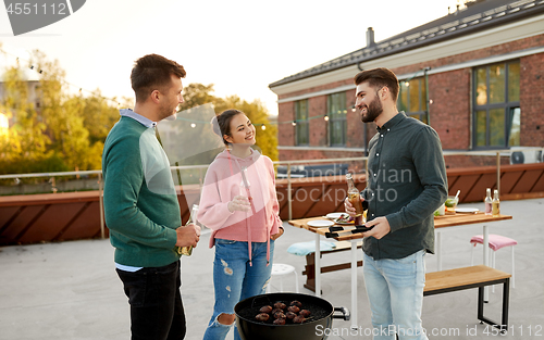 Image of happy friends having bbq party on rooftop