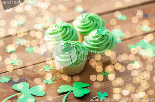 Image of green cupcakes and shamrock on wooden table