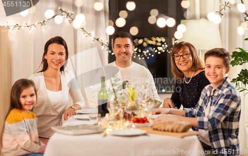 Image of happy family having dinner party at home