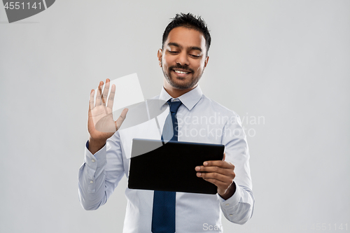 Image of indian businessman having video call on tablet