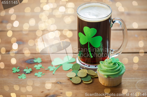 Image of shamrock on glass of beer, green cupcake and coins