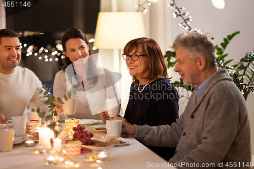 Image of happy family having tea party at home