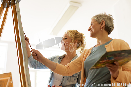 Image of women with brushes painting at art school
