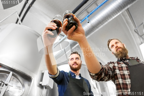 Image of brewers clinking glasses of craft beer at brewery