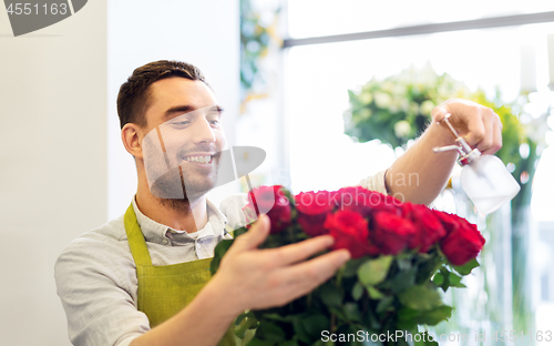 Image of florist or seller setting red roses at flower shop