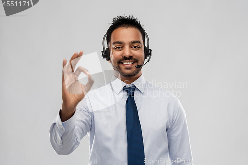 Image of businessman or helpline operator showing ok sign