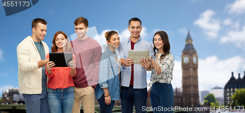 Image of group of friends with tablet computers over london