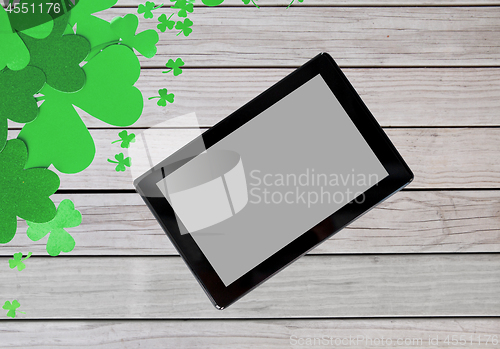 Image of tablet pc and st patricks day decorations on wood