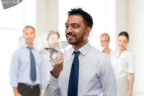 Image of businessman using voice command on smartphone