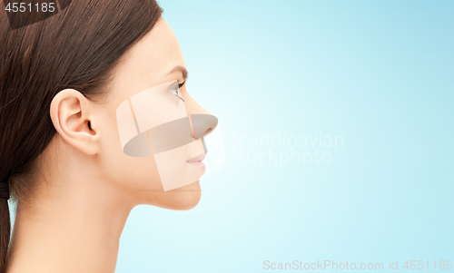 Image of beautiful young woman face over blue background