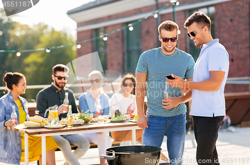 Image of happy friends having bbq party on rooftop