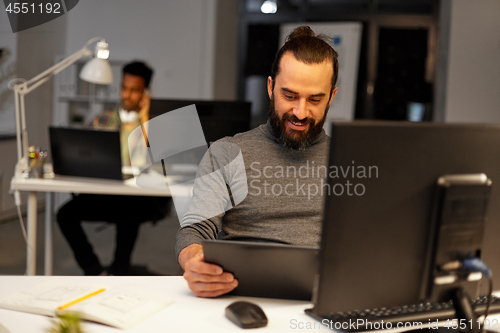Image of creative man with computer working late at office