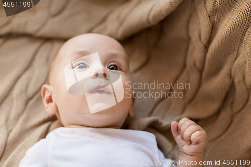 Image of sweet little baby boy lying on knitted blanket