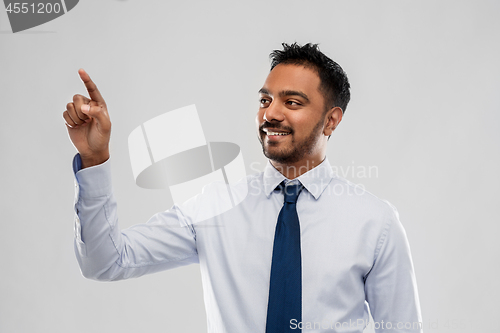 Image of indian businessman touching something invisible