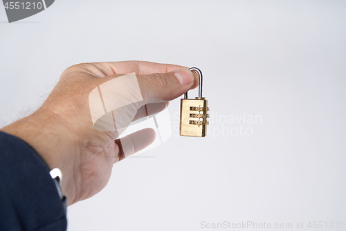 Image of Man\'s hand holding small combination lock
