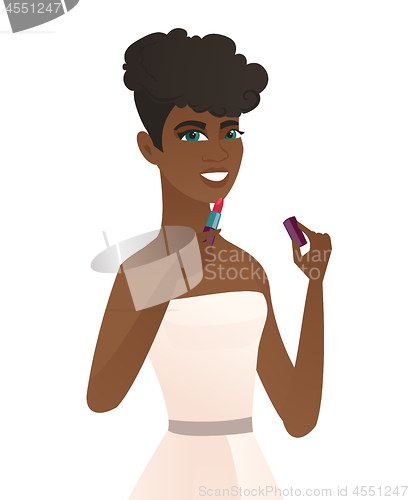 Image of Young african bride paints lips with red lipstick.