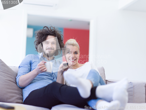 Image of Young couple on the sofa watching television