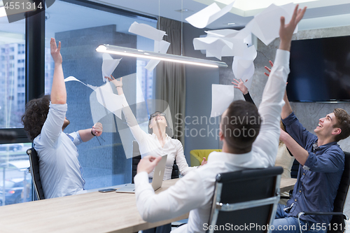 Image of startup Group of young business people throwing documents