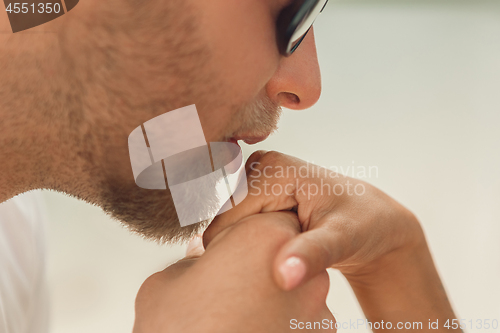 Image of She said him yes. Closeup of young man kissing his wife hand while making marriage proposal outdoors.