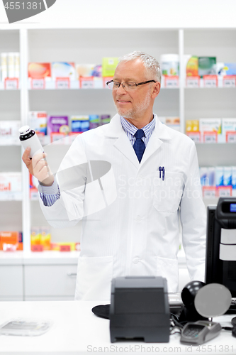 Image of senior apothecary with drug at pharmacy