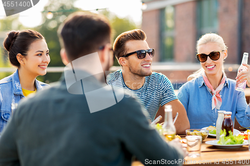 Image of friends having dinner or bbq party on rooftop