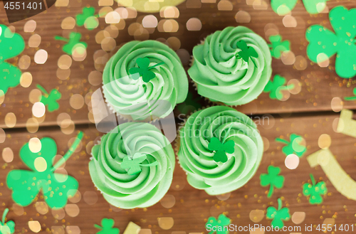 Image of green cupcakes and shamrock on wooden table