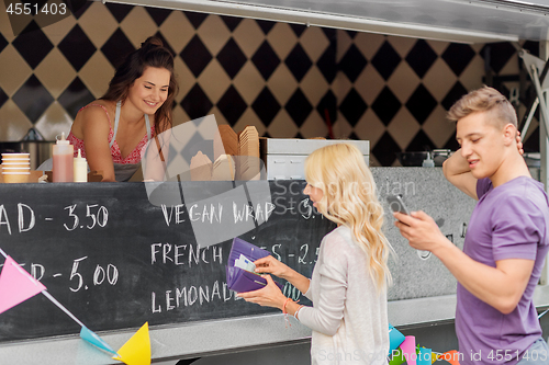 Image of queue of customers and saleswoman at food truck