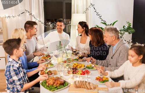 Image of happy family having dinner party at home