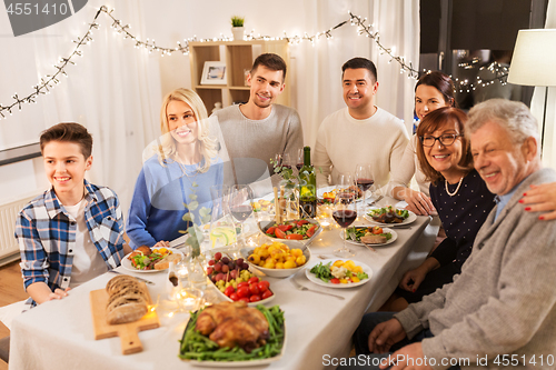 Image of happy family having dinner party at home