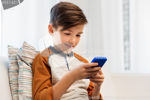 Image of happy smiling boy with smartphone at home