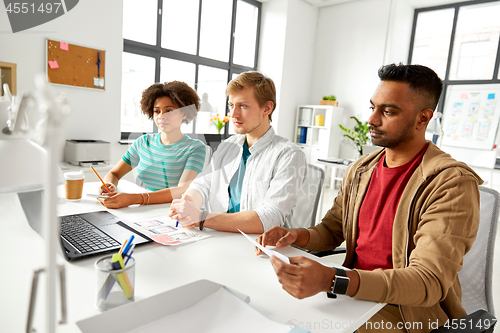 Image of happy creative workers with laptops at office