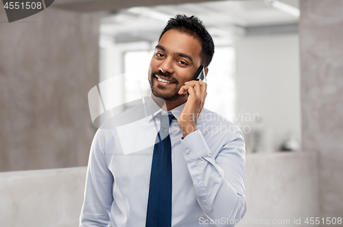 Image of indian businessman calling on smartphone at office