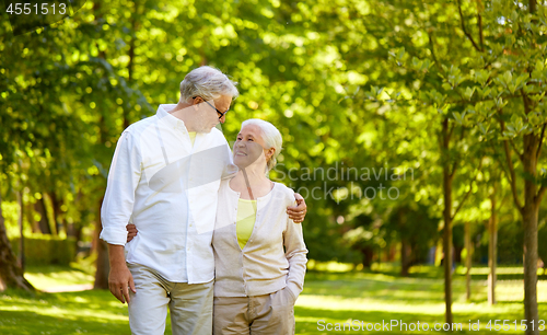 Image of happy senior couple hugging in city park