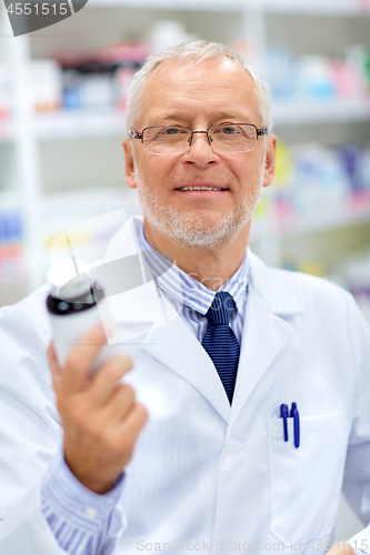 Image of senior apothecary with drug at pharmacy