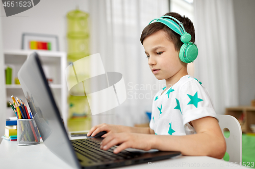 Image of boy in headphones playing video game on laptop