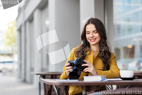 Image of tourist or teenage girl with camera at city cafe