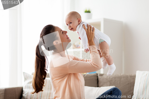 Image of happy mother playing with little baby boy at home