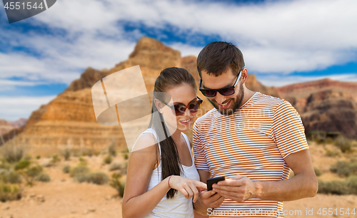 Image of happy couple with smartphone in summer