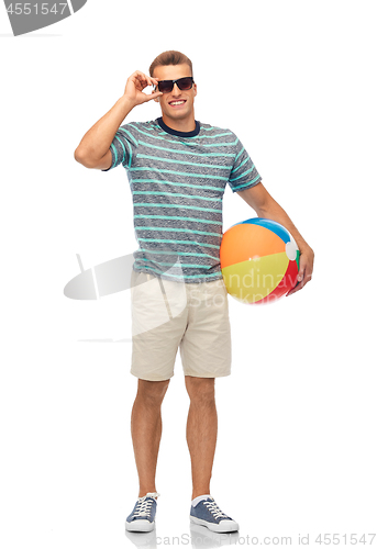 Image of smiling young man in sunglasses with beach ball