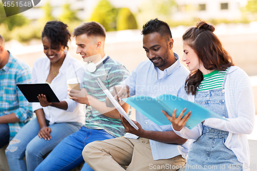 Image of international students with notebooks outdoors