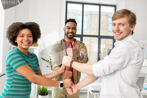 Image of happy creative team making high five at office