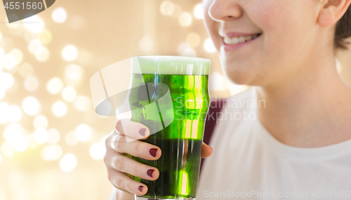 Image of close up of woman with green beer in glass