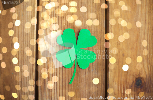 Image of green paper shamrock on wooden background