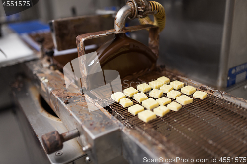 Image of candies processing by chocolate coating machine