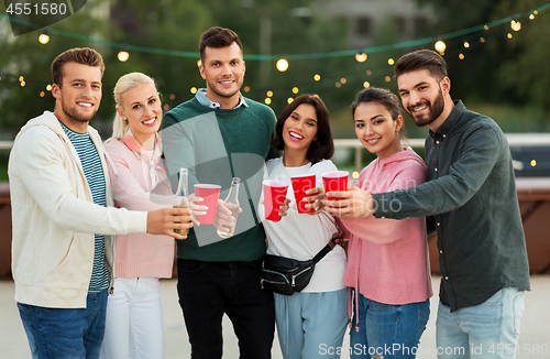 Image of friends with drinks in party cups at rooftop