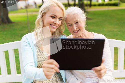 Image of daughter with tablet pc and senior mother at park